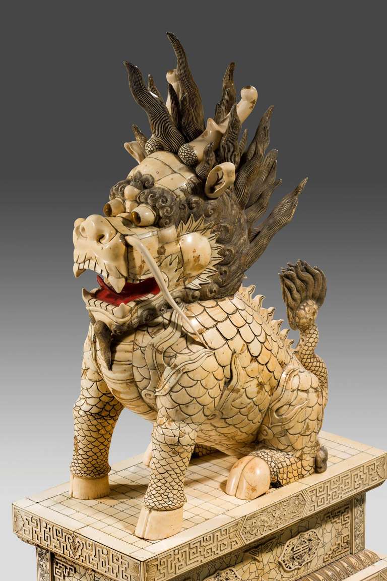 A massive and magnificent Pair of Ivory Kylins, with complex carved and tinted details resting upon rectangular bases with blind fret carving and insignia of exceptional quality and condition.

The kylin is an animal in ancient Chinese mythology.