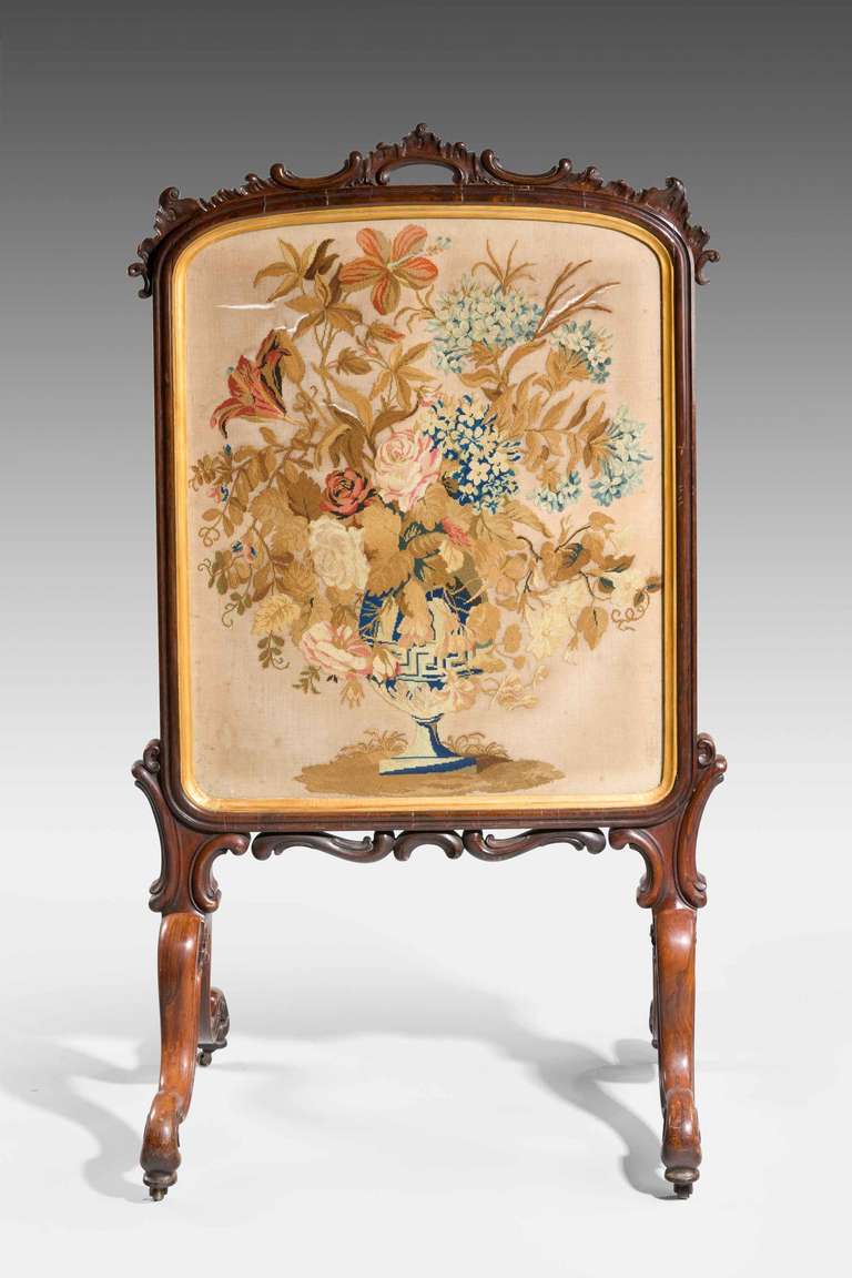 Mid-19th century fine fire screen, the needlework finely executed centre within a gilded border surrounded by a shaped rosewood outer frame.