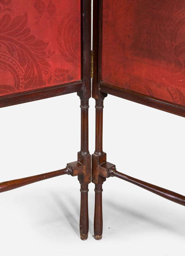 George III period mahogany two-fold hinged screen on square section and turned supports.