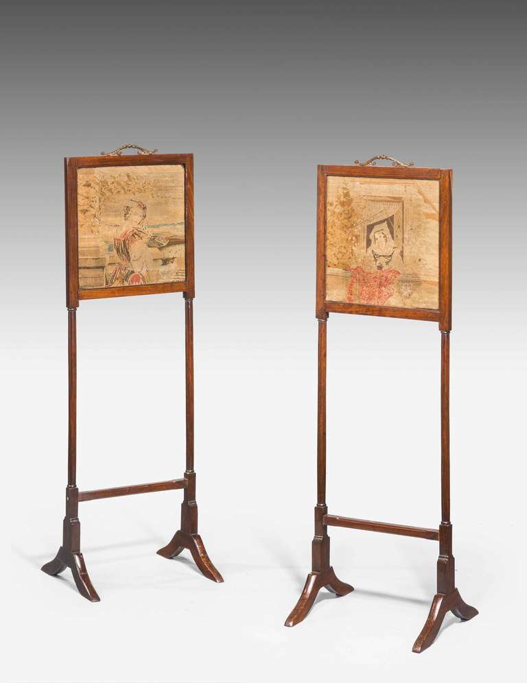 An unusual pair of George III period small screens incorporating period petit point embroidery with original well cast gilt bronze handles.