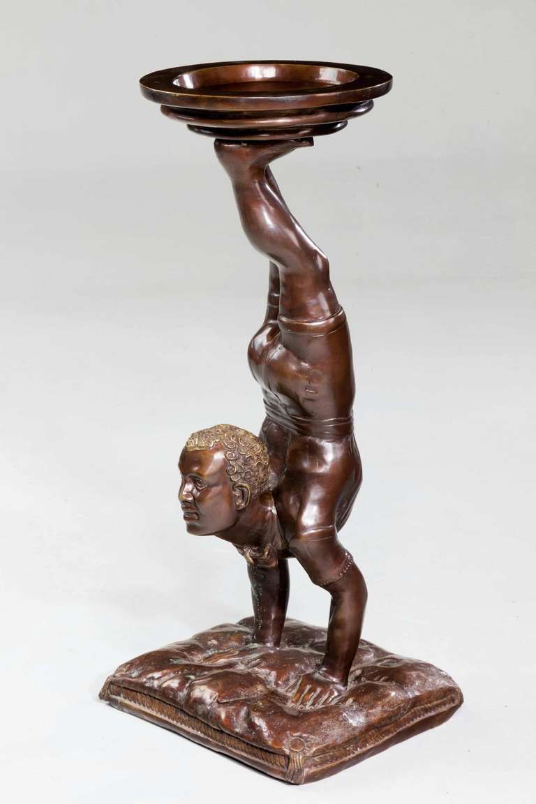 An unusual late 19th century Italian bronze figure of an Acrobat in the form of a jardinière stand to support a floral arrangement. Dark bronze patina, the figure on a cushion base.

