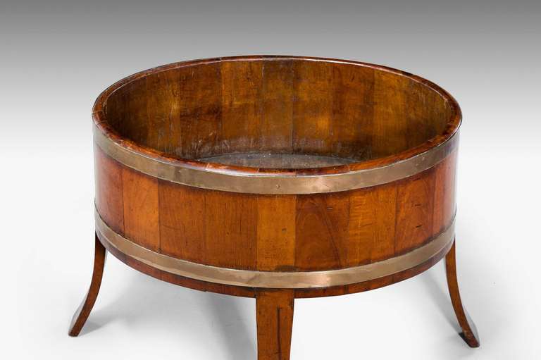 A late 19th century oak wine cooler of unusually flared flat form, with two broad and original brass bands, the sides being very well figured.

RR.
