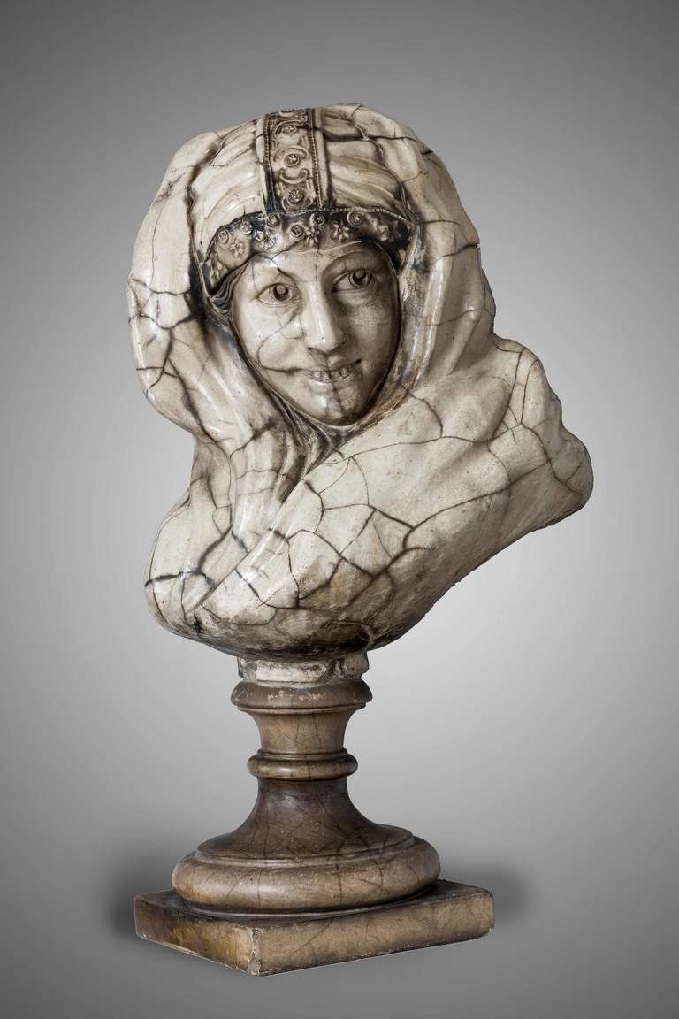 A late 19th century marble bust of an Arab beauty, the crazed body over the turned socle.