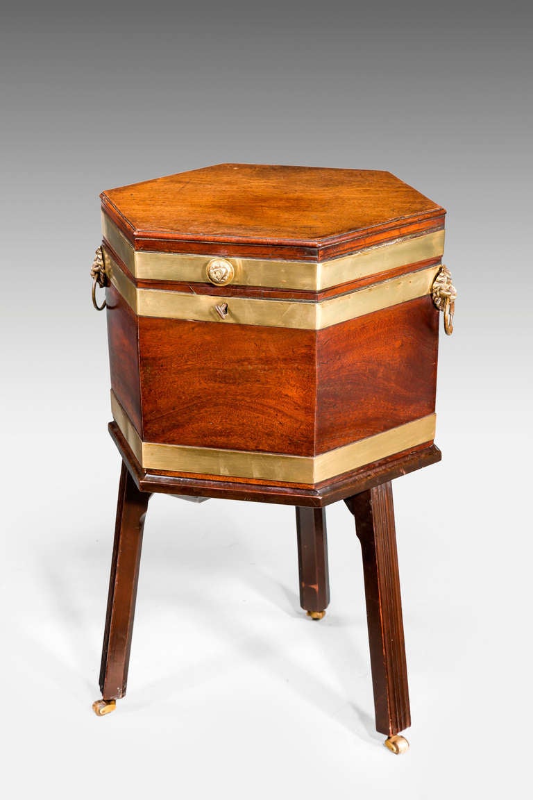 A Chippendale period hexagonal mahogany wine cooler, the top and body with broad brass bindings, the interior with its original lead linings.

RR.