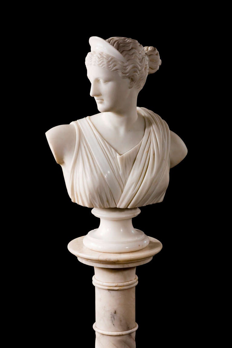 A finely carved marble Bust of a young girl, in neo-classic drapes, to dexter, on a figured writhen column.