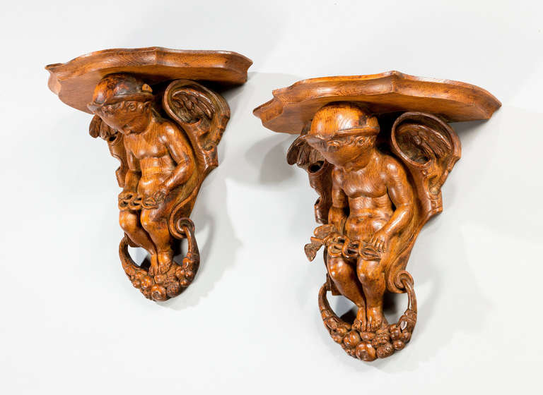 A very well carved pair of 19th century pine serpentine brackets, the supports of Putti, with foliage, flowers and fruit.

