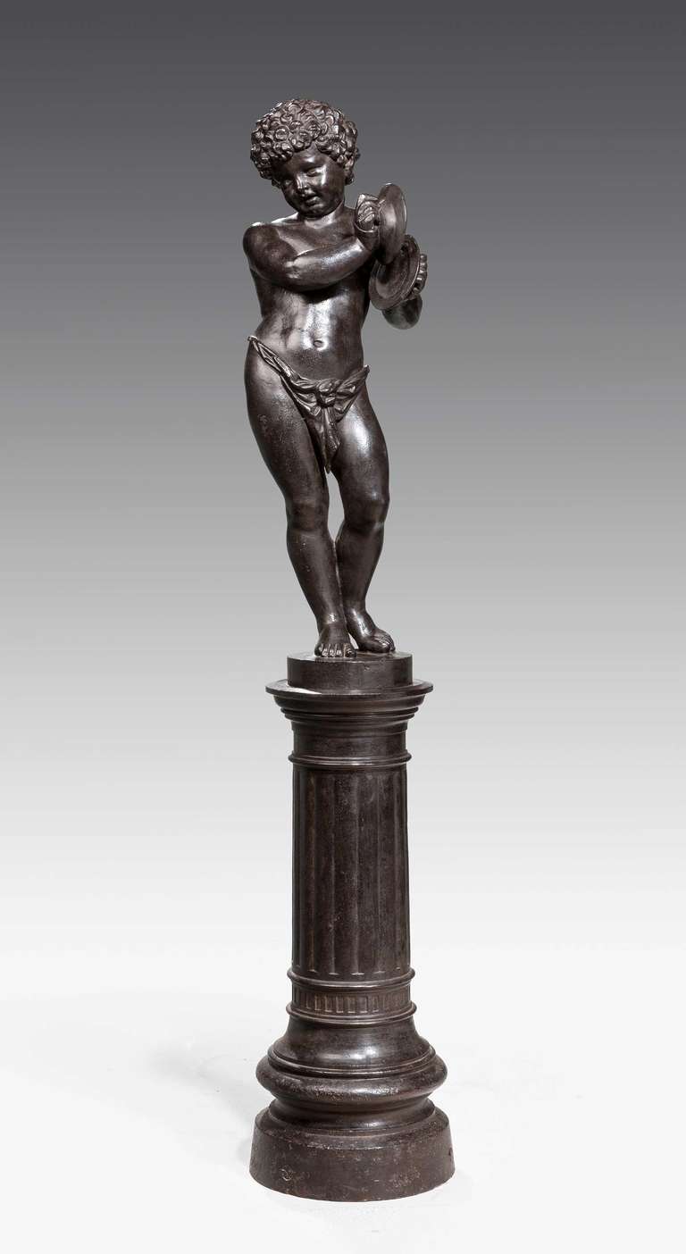 A fine bronze patinated cast iron figure on a fixed pedastal of a Putti playing cymbals by Val D'osne. Val osne is a deviation from the common Osne-le-Val in Haute-Marne. Workshops, created in 1836 by Jean-Pierre Victor Andre to make street