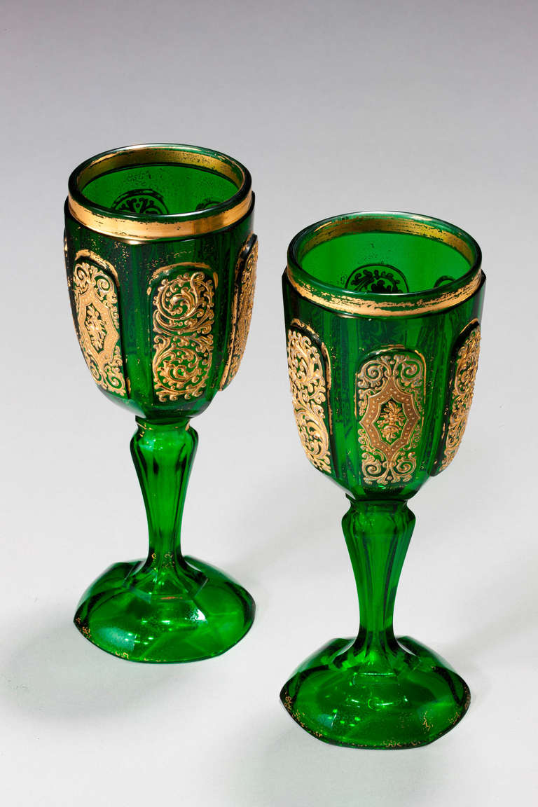 Pair of Bohemian dark green glass goblets with raised panels incorporating gilded decoration .

Bohemia was a part of the Austro/Hungarian Empire now part of the Czech Republic and was famous for its beautiful and colorful glass. The history of