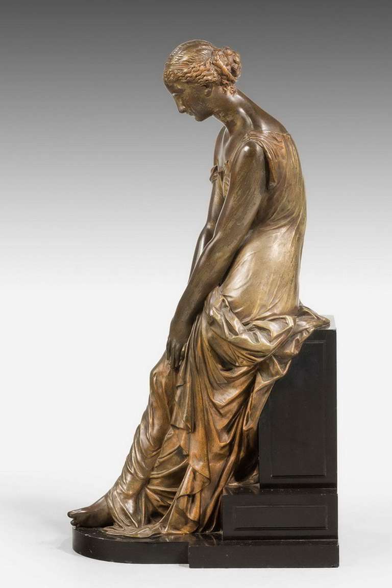 A bronze 19th century seated maiden on a stepped black marble, beautifully modeled with the softest of gilded highlights, original surface and color. RR.