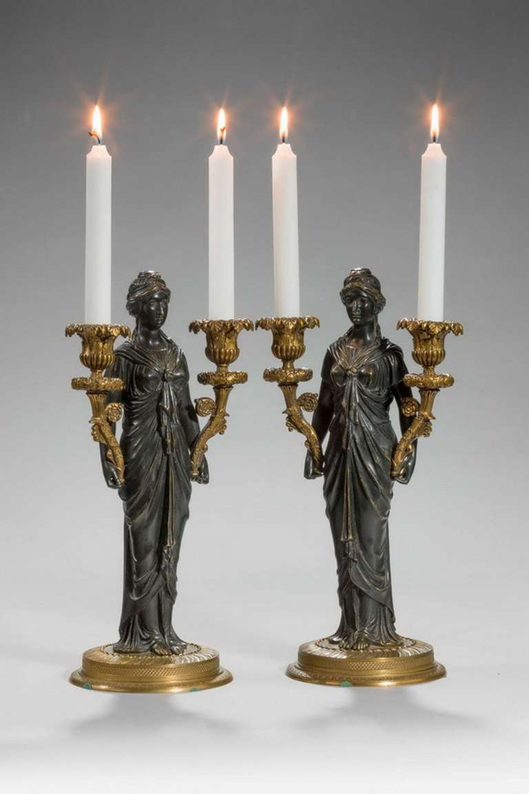 A good pair of English 19th century bronze candelabra figures with complex bases and writhen, scrolled and milled decoration.