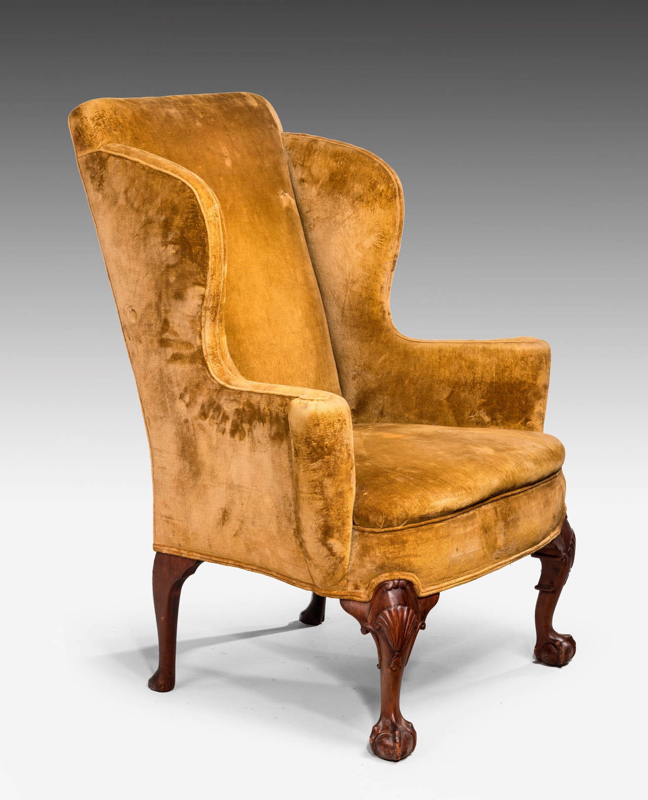 An elegant and well-shaped late 19th century walnut framed wing chair. With flared arms on shaped supports, terminating in claw and ball feet. Very good overall design.

An 18th or 19th century wing chair is an easy chair or club chair with
