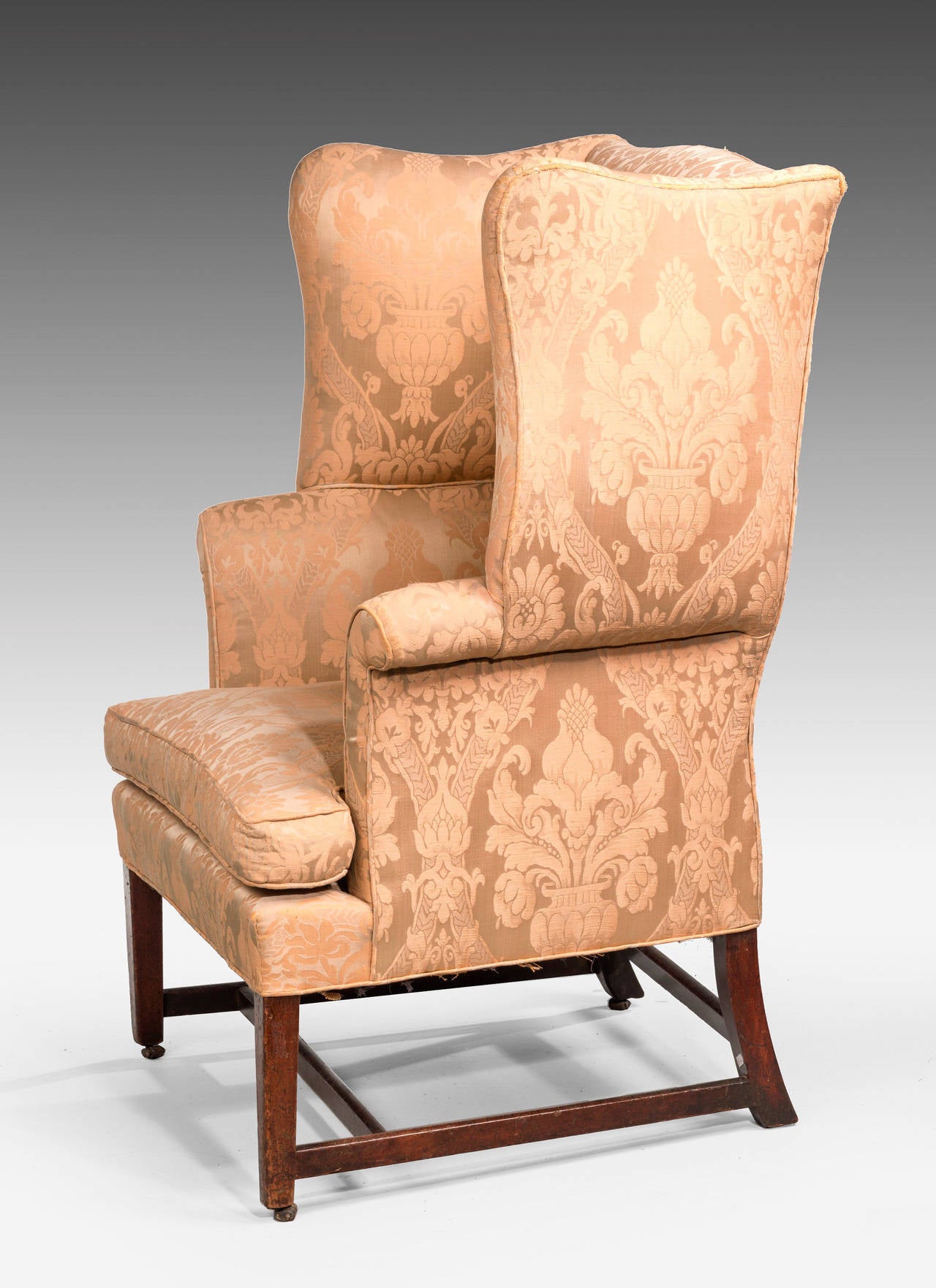 Une chaise à oreilles d'époque Chippendale en acajou. Avec des ailes serpentines bien formées et prononcées. Sur des supports carrés très légèrement effilés:: reliés par un support en H. Bonne forme du point de vue de Silhouette.