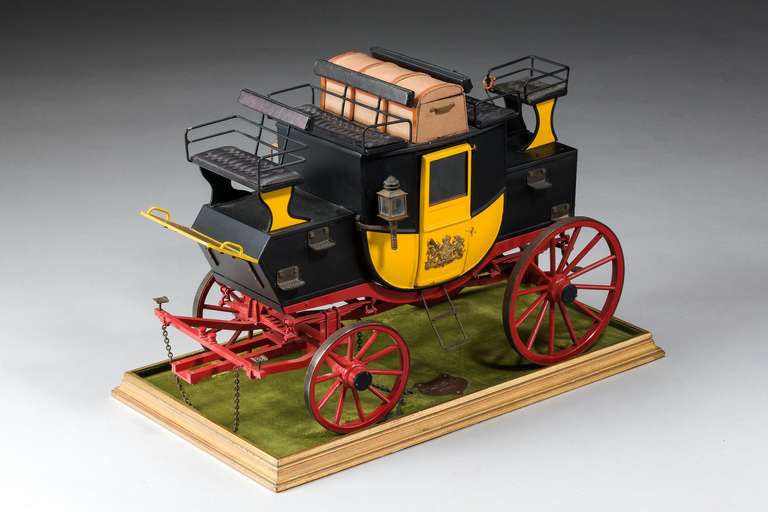 A fine model mail coach baring a plaque suggesting 1834 design, in tole ware and decorated wood. The interior with fitted bucket seating and a quilted door, the luggage compartment opening, in excellent overall condition.

RR.