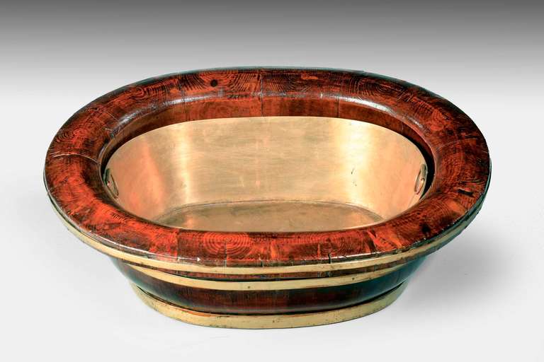 A late 19th century elm oval baby’s bath coopered in traditional manner with a modern made brass liner the top, beautifully figured in oysters, South China.