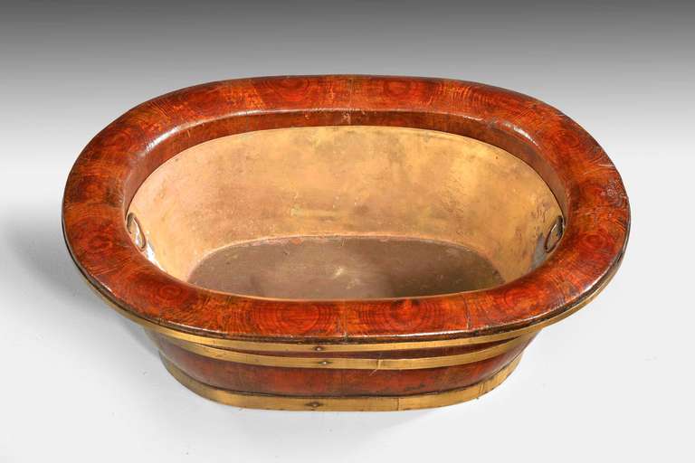 A late 19th century elm oval baby’s bath coopered in traditional manner with a modern made brass liner the top, beautifully figured in oysters. South china.