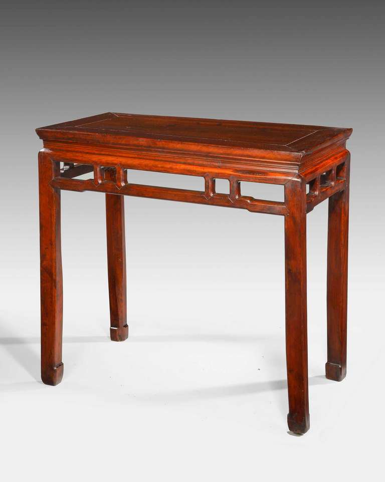An attractive 19th century elm half table on square chamfered supports the top with an architectural pierced border south China.