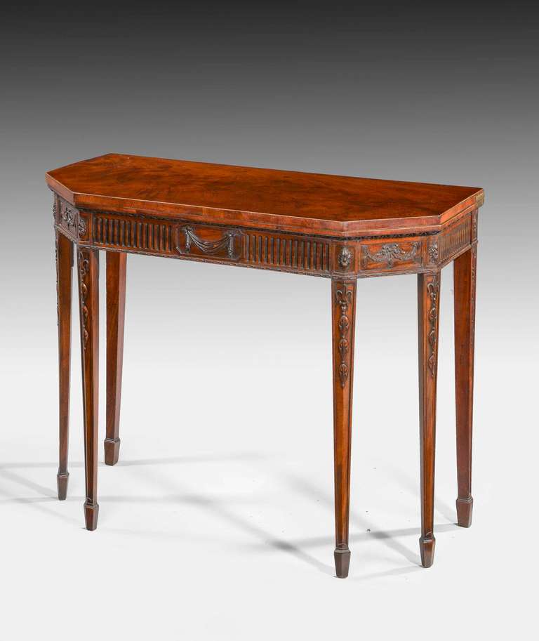 A quite exceptional George III period mahogany card table. The interior with a dark suede panel, the corners are set with finally carved details of swags and urns. Tapering feet with elaborately carved inset detail, the whole of exceptional design