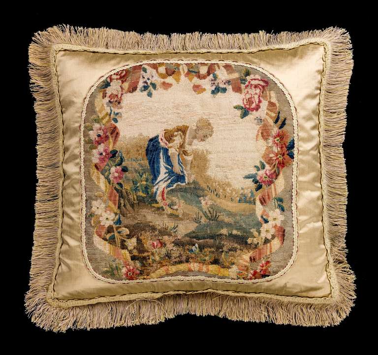 French, mid-18th century silk and wool. A young woman tending a garden with muted colors within an overall floral framework.

RR.
