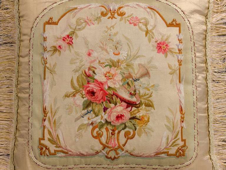 Late 18th century, French, wool with silk highlights. A bouquet of flowers within a border of flowers and foliage with a soft outer edge.

RR.