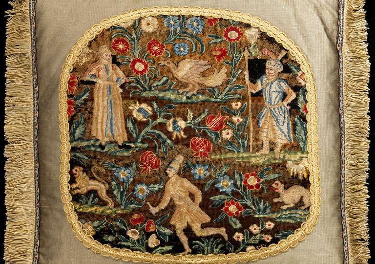 Mid-18th century, French, silk and wool with silk highlights. A richly colored gros and petit point cushion with figures and an exotic bird with a background of foliage and flowers, an imaginary lion to one side. The figures in open-stitch