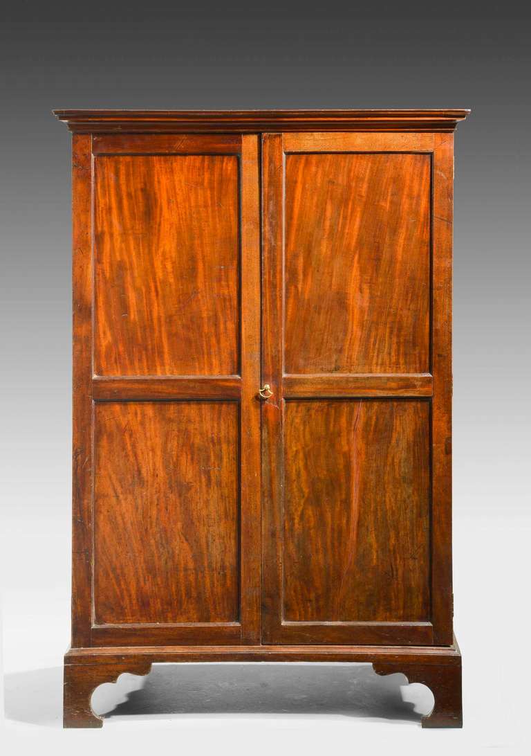 A Chippendale period mahogany wardrobe. The top with moulded corners on strongly formed bracket feet.