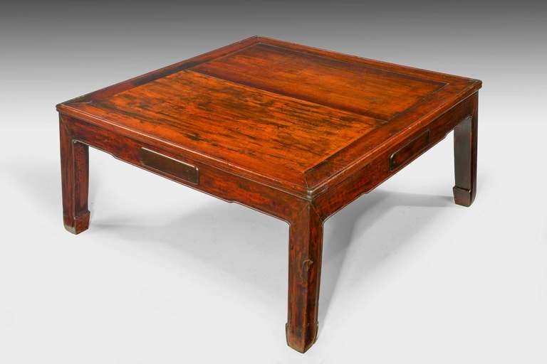 A late 19th century Oriental elm low table with a square section top,with four concealed draws.