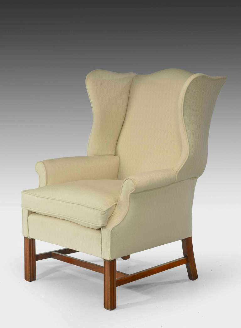 A mahogany framed wing chair of Chippendale design with strong and well-shaped serpentine arms the supports chamfered with an H-stretcher. Now covered with an oat meal fabric totally reupholstered

RR.