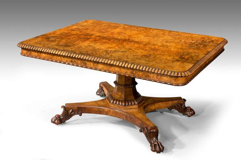 Signed Gillows of Lancaster. An exceptionally fine rectangular rarly 19th century centre table in burr walnut with a quartered top and a continuous gadrooned edge. A Swept octagonal support over quatrefoil platform base on finely carved paw