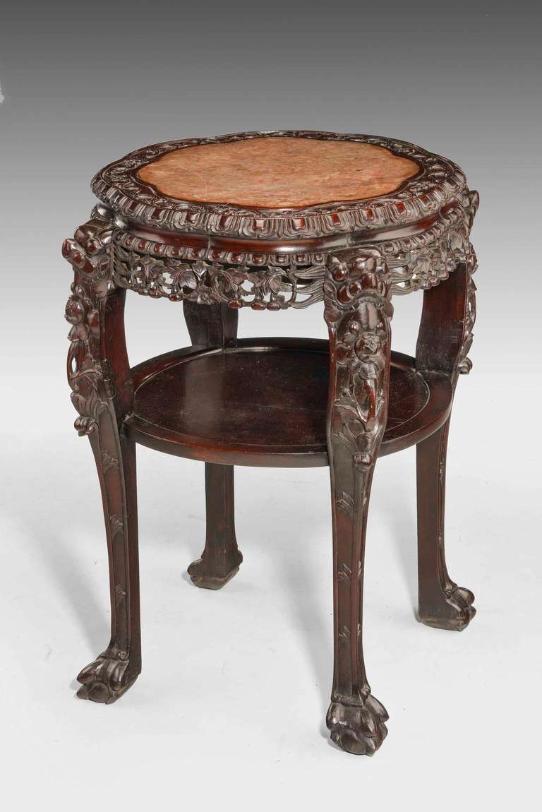 A very good quality 19th century Chinese hardwood two-tier stand, the top shelf retaining its original inset, well figured marble section. The freeze finely carved with leaves, fruit and foliage. Gently shaped cabriole supports ending in carved toes.