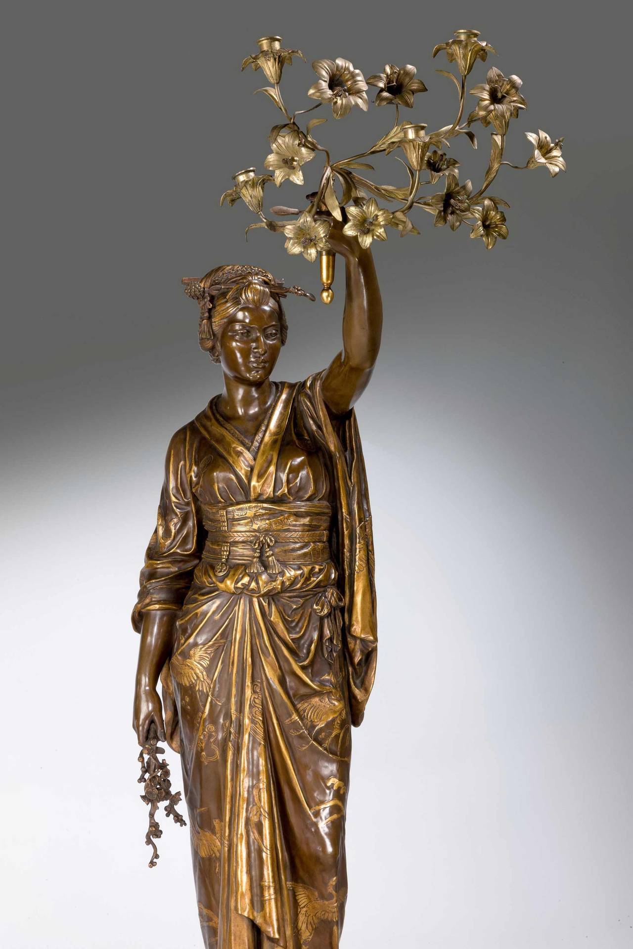 A fine pair of bronze and gilt bronze sculptures both signed F Barbedienne and Ele Guillemin.
Each in the form of a standing Japanese female figure in a kimono, one embroidered with prunus, the other with cranes, one with a fan in her hand, the
