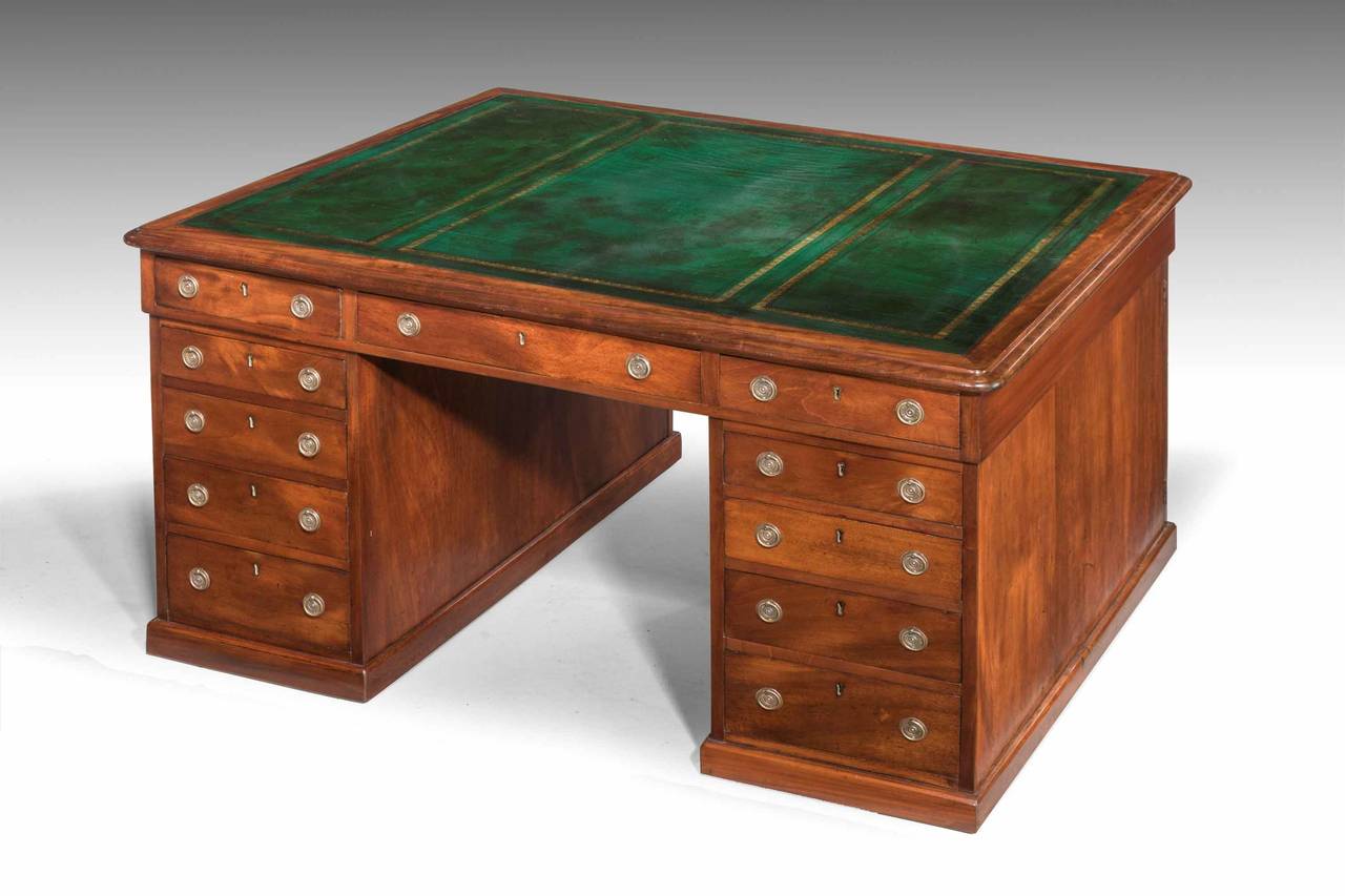 Late Regency period mahogany three-part pedestal desk, one side with 13 drawers, the reverse with three drawers and cupboards, leather inset top retaining original handles.