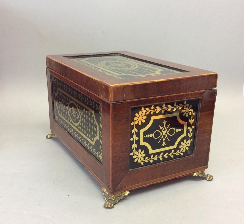 Early 19th Century Mahogany Caddy with fine eglomise panels and retaining original gilt bronze feet, the decoration in overall excellent condition with faux shark skin paper to the interior.Minor repairs to the lid.