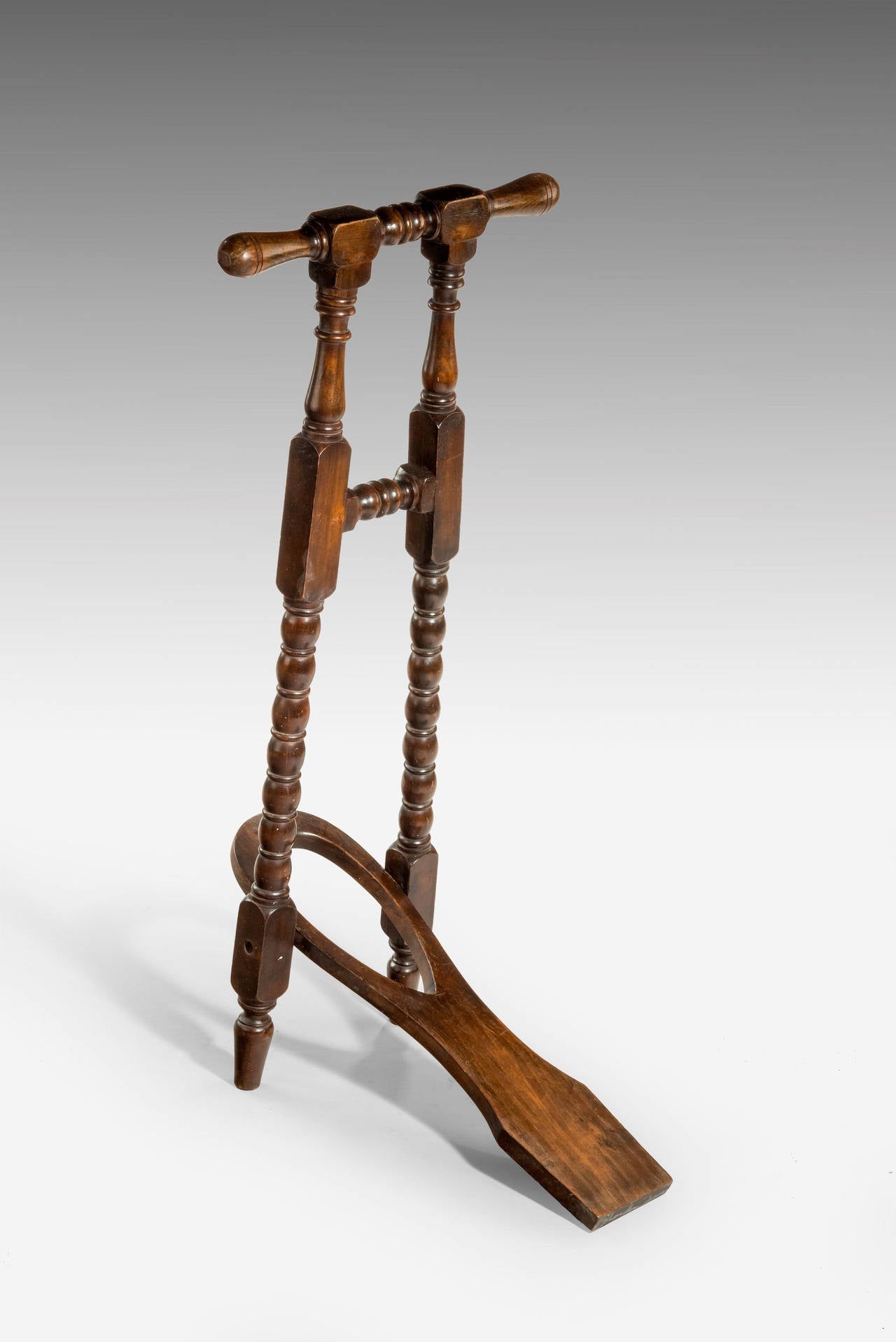 A mahogany boot jack with well carved central sections. Good overall condition.