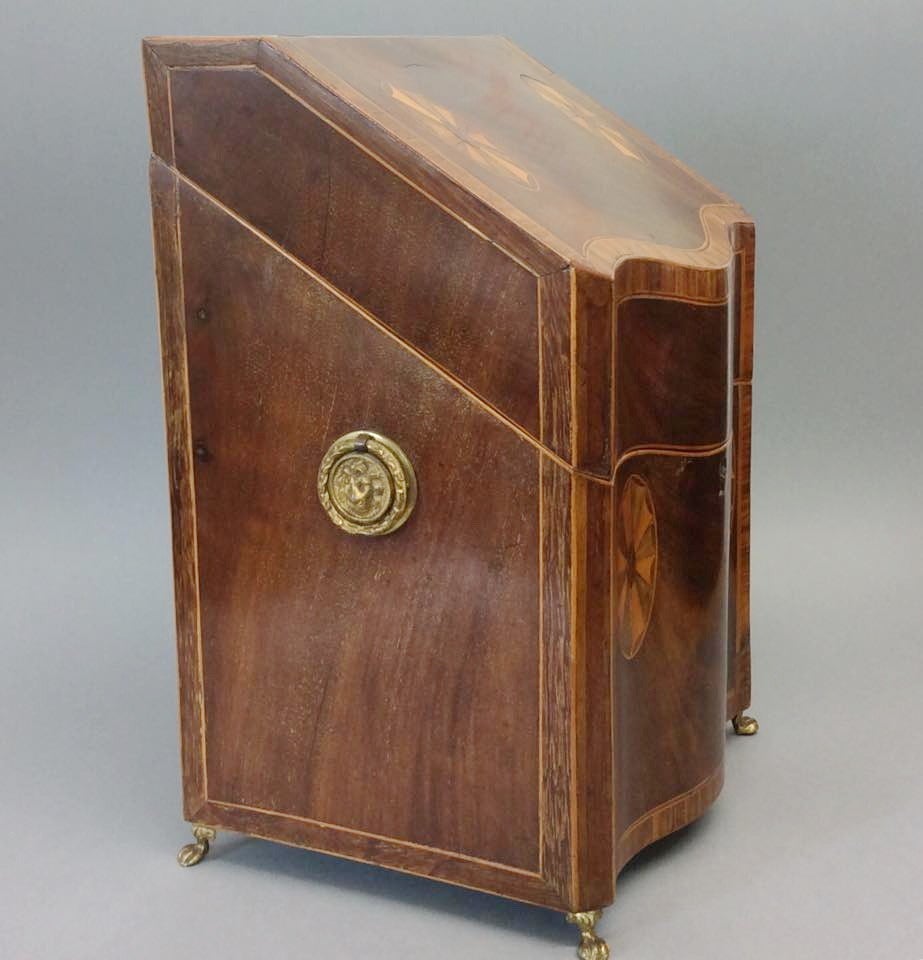 19th century mahogany serpentine fronted knife box with shell inlay and crossbanding to the front and sides, well cast lion's head handles, terminating in brass claw feet, the whole now converted to stationery.

RR.