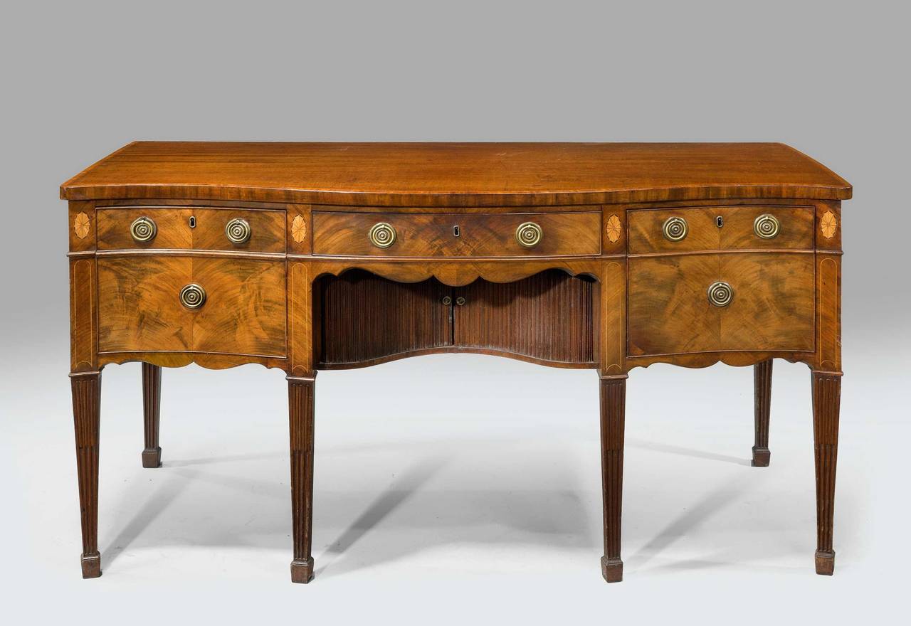 George III period mahogany sideboard of very well-known design by Gillows of Lancaster. The top crossbanded and the uprights with oval paterae, good period brass, square tapering supports and reeded and incised carving to the lower section with a