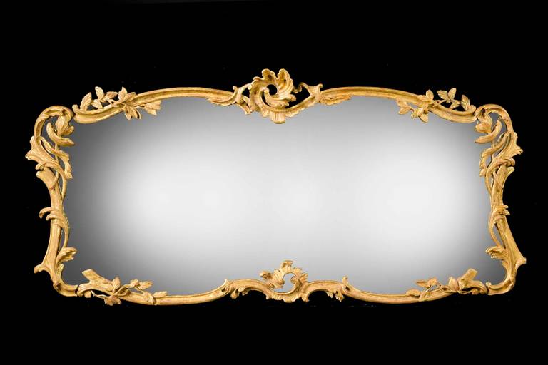 A Chippendale period overmantel landscape shaped mirror. The Rococo frame finely carved with cartoshe and foliage. Replaced plate.

