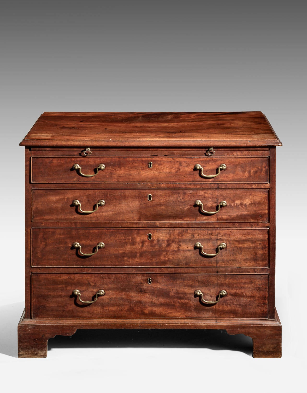A very well figured George III period mahogany chest of drawers with good period swan necked handles. The top section incorporating a slide. Very highly figured top. Period bracket feet.