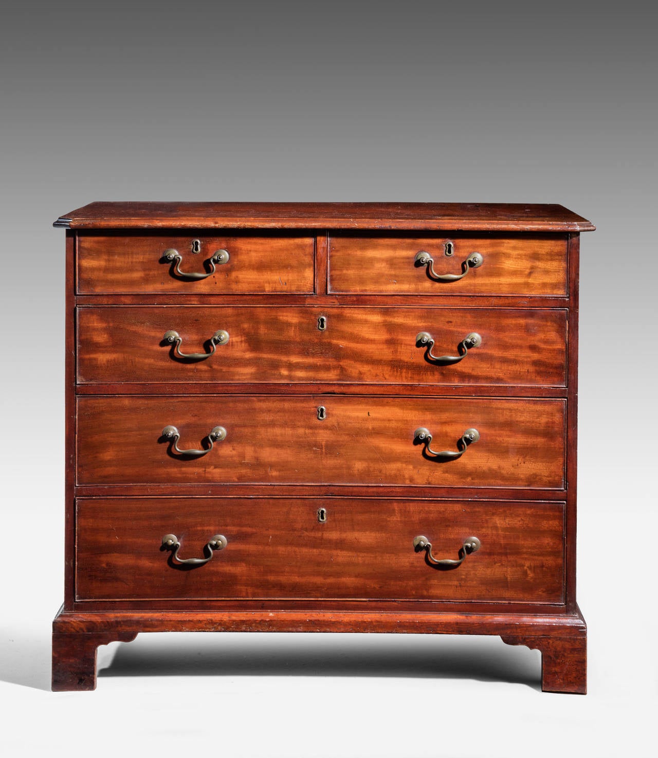 A George III period mahogany chest, of good colour and patina. The top showing ware marks. Very much commensurate with the age. Good swan neck period brass handles and oak lined drawers. Original bracket feet.