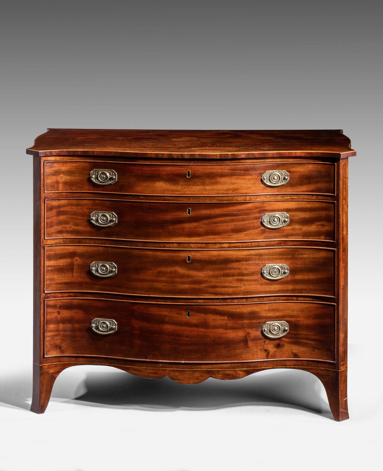 A good George III period serpentine chest of drawers. The top with serpentine ends, edged in boxwood. Fine original period handles. On high swept bracket feet.