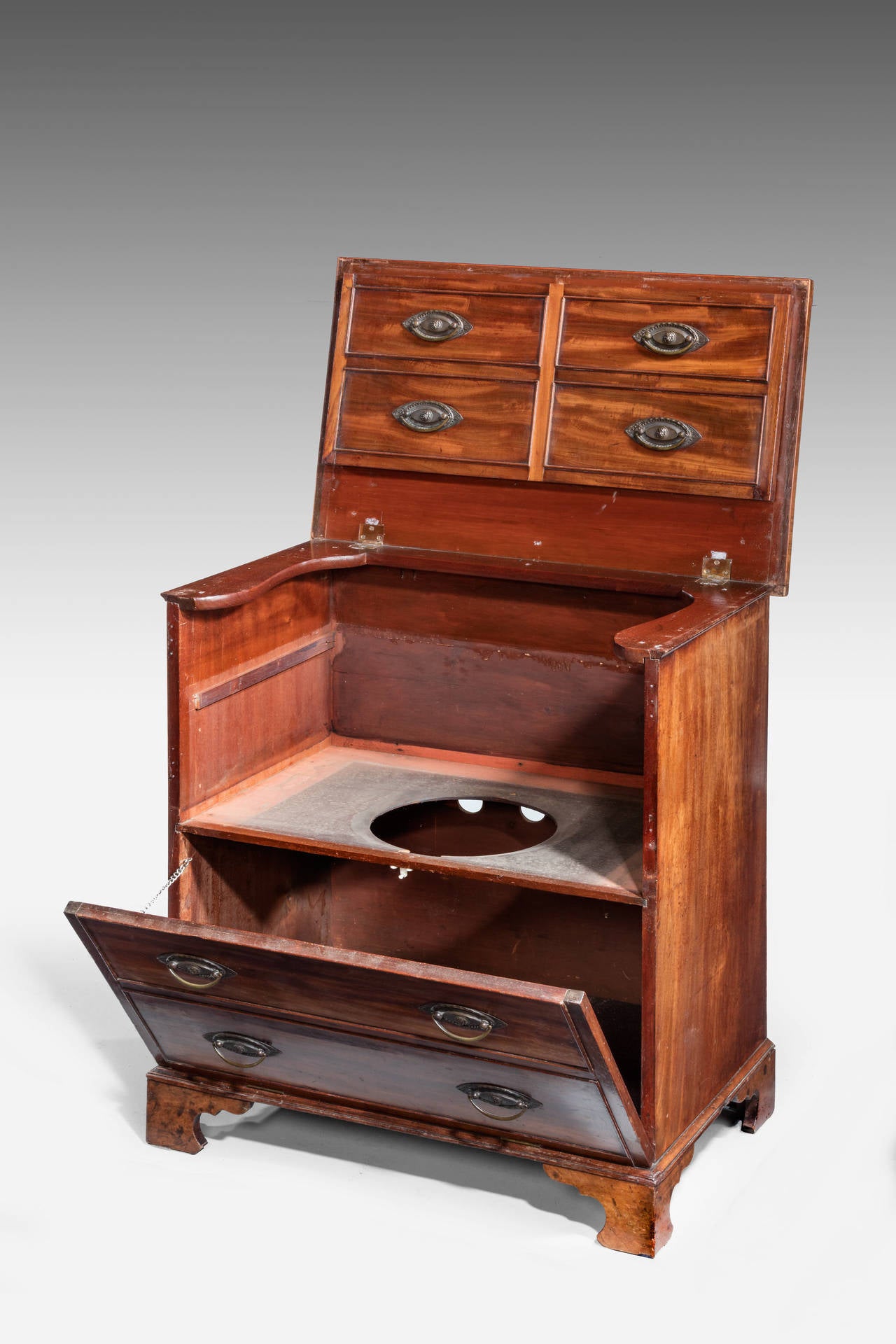 A Late George III Period Mahogany lift top Commode, now with a lined out centre section. Pretty oval Sheraton handles. The top cross banded

