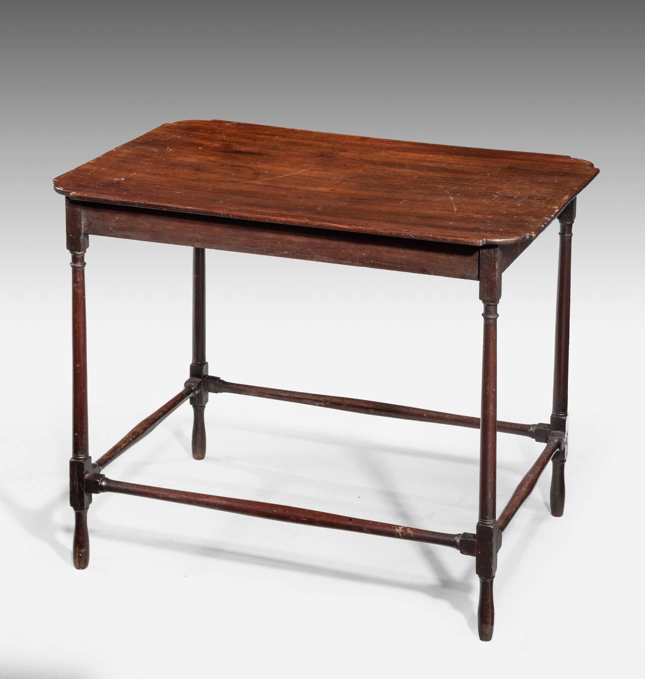 An attractive Late 18th Century Mahogany Centre standing Occasional Table. The top with cusb and shaped corners. Finely turned supports with original cross stretchers to the base section.

RR