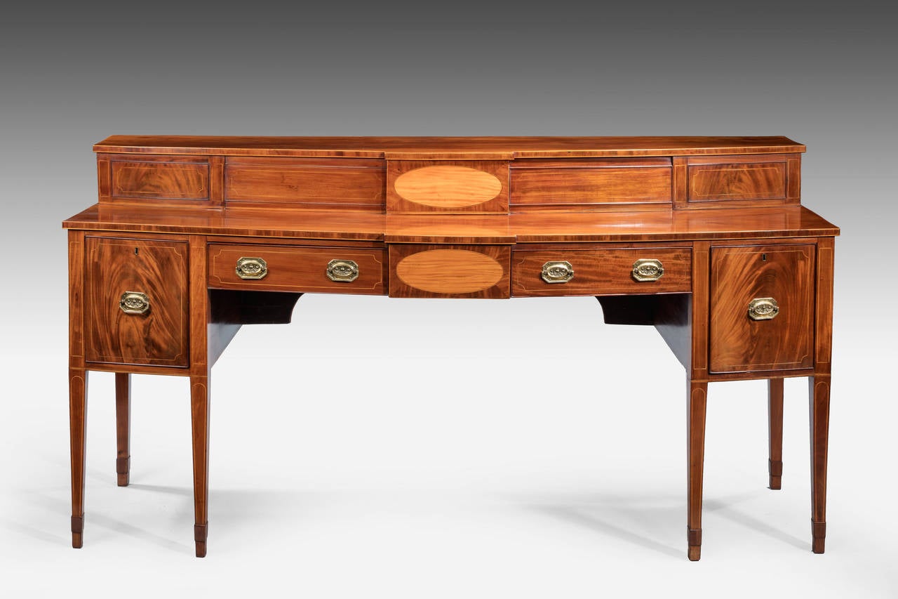 A fine George III period mahogany bow-front sideboard, with an upper section to the rear, likely Scottish. Edged in boxwood and satinwood and with oval inlaid sections. Square tapering supports, with bandage sections to the base of the legs.

