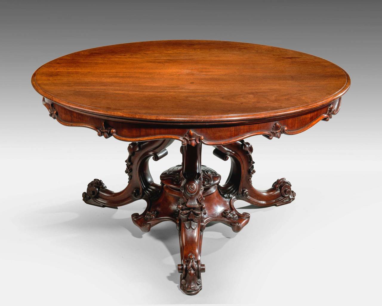 A very fine quality and well carved Victorian mahogany centre table. On elaborate cabriole supports, ending in a high French scroll foot. The top with a continuously carved border of leaves and foliage.

RR.