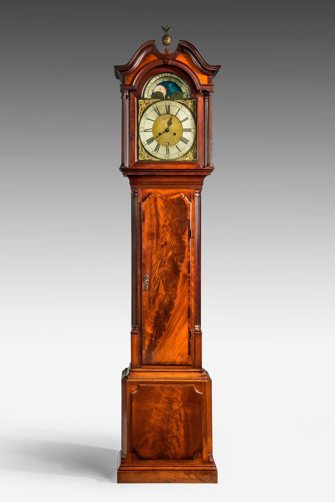 18th century mahogany longcase clock by John Parker of Liverpool with an eight day movement. Fine swept arch hood above an eagle finial, the face with a silver chapter ring showing Roman numerals, the upper section with phases of the moon retaining