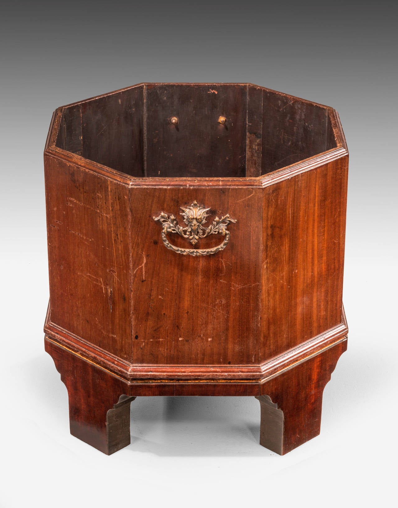 An unusual 19th century octagonal mahogany wine cooler on a separate base with bracket feet. Complex cast bronze gilt bronze handles. Well figured timbers.

