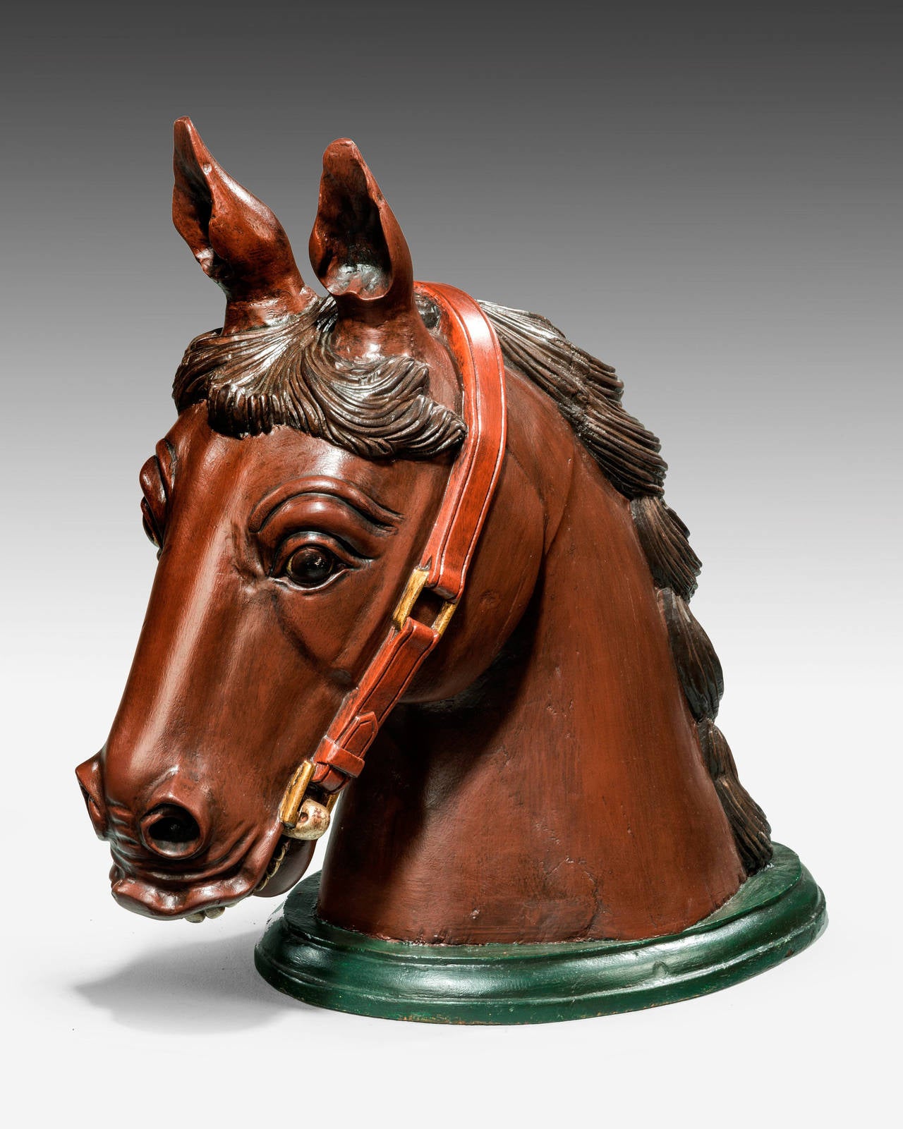 An early 20th century large and finely carved horse head mount. The dark nut brown surface highlighted with some gilding.