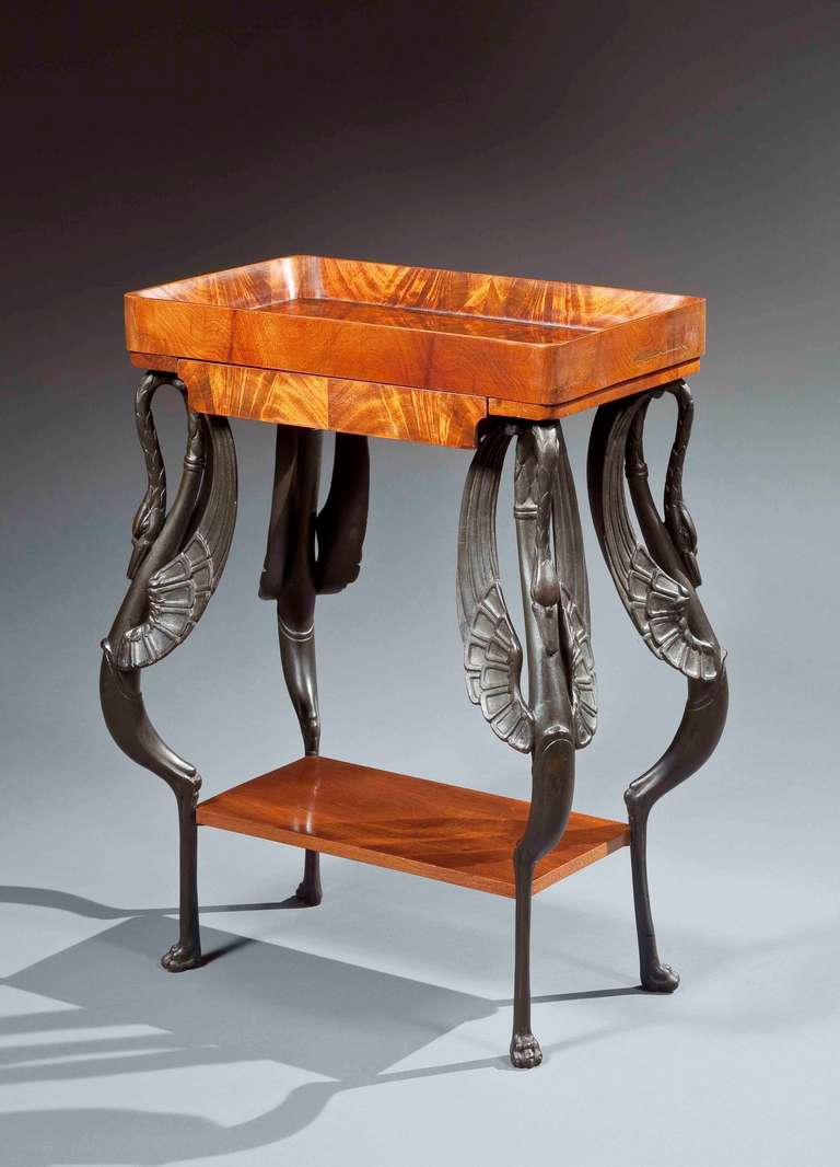 A beautiful mahogany 'vide-poche' table, with a recessed surface and wood carved swan legs painted black.