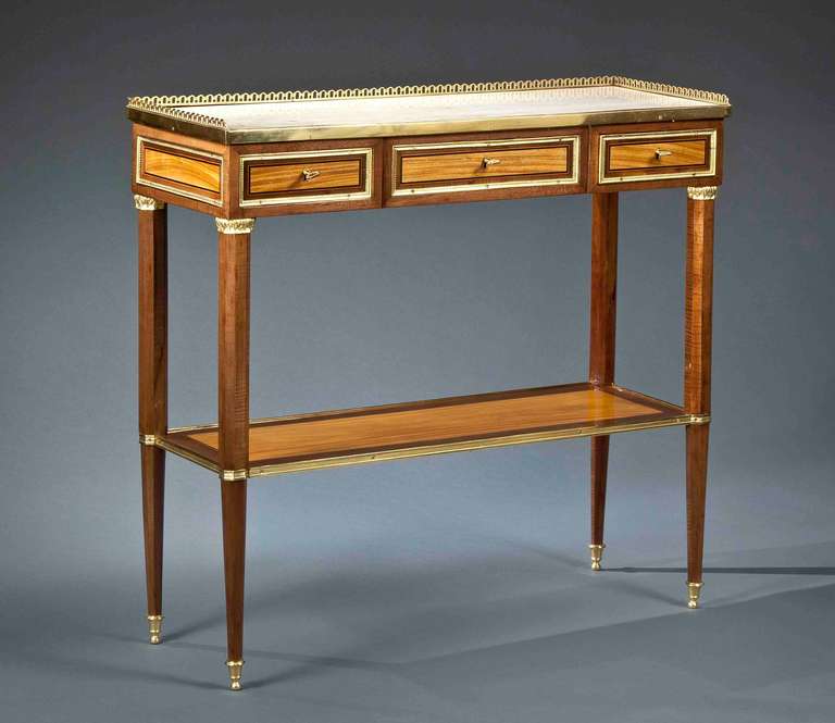 The rectangular white marble top with a three-quarter gallery, above three drawers, raised on octagonal tapering legs joined by platform stretchers.