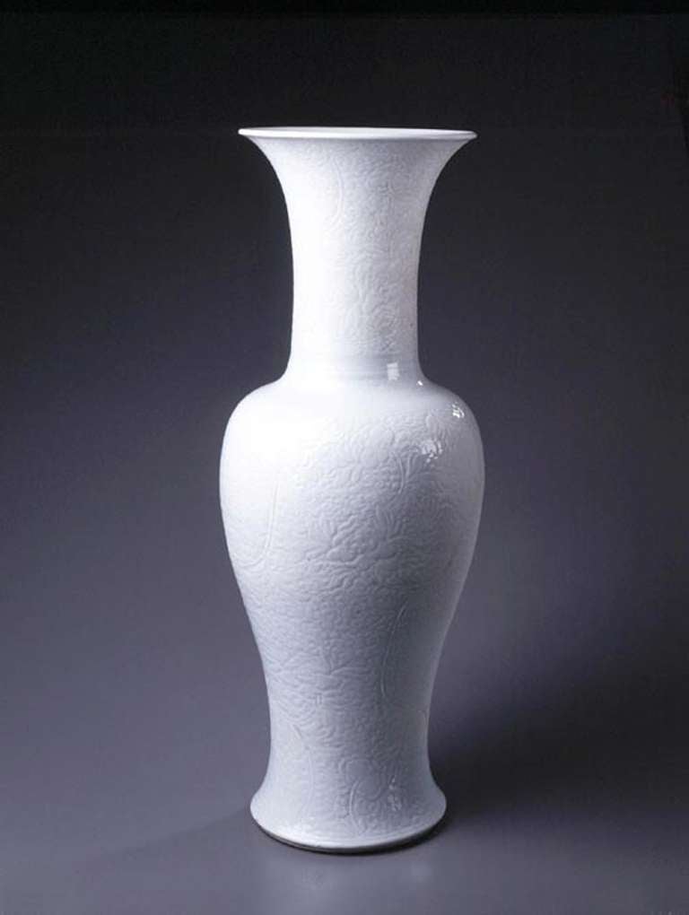 This large and impressive vase of the yen yen shape strikes an elegant profile. Boldly decorated beneath the glaze with impressed and incised motifs, the strength of the floral designs balances the powerful form. The body and the neck display a