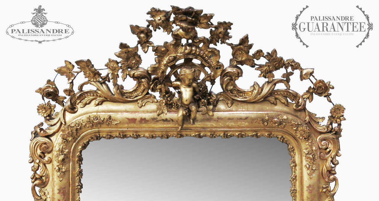 Majestic mirror Elizabethan masterpiece of the 19th century made in wooden frame carved and gilded divided into three bands: the traveled abroad by a wreath of acanthus; intermediate with sprigs of flowers carved created leaving brown the armenian